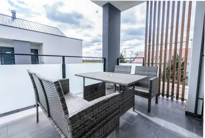 a balcony with a table and chairs on a building at Apartments Sunrise Banovci in Banovci