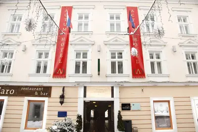 a white building with red banners on it at Hotel Actum in Kranj