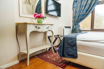 a bedroom with a bed and a table with a flower on it at Hotel Actum in Kranj