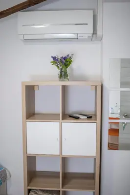 a wooden shelf with a vase of flowers on it at Borea Rooms - Sobe Budanje in Vipava
