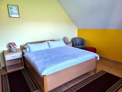 a bedroom with a bed and a chair in it at Bed and Breakfast Valjavec in Kranj