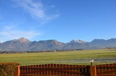 a fence in a field with mountains in the background at Bed and Breakfast Valjavec in Kranj