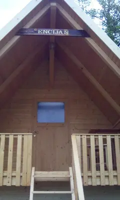 a front door of a wooden building with a sign on it at farmglamping Planika - Encijan in Hraše