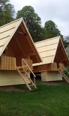 a house with a pitched roof and two stairs at farmglamping Planika - Encijan in Hraše