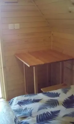 a room with a wooden table in a cabin at farmglamping Planika - Encijan in Hraše