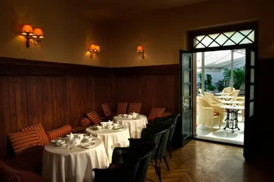 a dining room with tables and chairs and a patio at Hotel Slamič Ljubljana in Ljubljana
