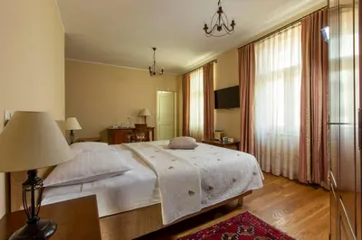 a bedroom with a bed and a table and a lamp at Hotel Slamič Ljubljana in Ljubljana
