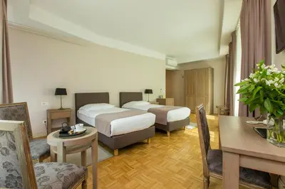 a hotel room with two beds and a table at Hotel Slamič Ljubljana in Ljubljana