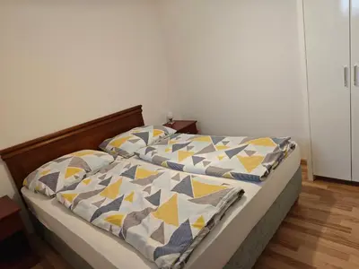 a bed with a quilt on it in a bedroom at Apartmaji Pri Kokolu in Bled