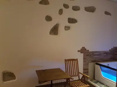 a room with a table and a tv and a chair at Apartments Fazarinc with parking, wellness and city store in the center of Celje in Celje