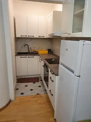 a kitchen with white cabinets and a white refrigerator at Apartments Fazarinc with parking, wellness and city store in the center of Celje in Celje