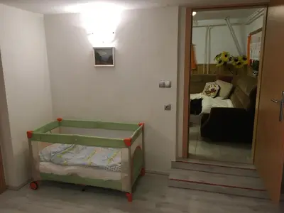 a small room with a crib and a mirror at Apartma Metka in Mojstrana