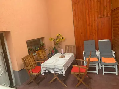 a patio with a table and chairs in a room at Apartma Metka in Mojstrana