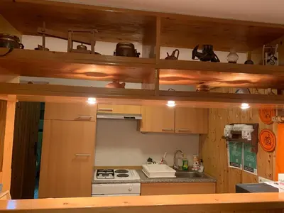 a kitchen with wooden cabinets and a stove top oven at Apartma Metka in Mojstrana