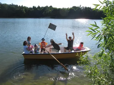 a group of people in a boat on a lake at MCC Hostel in Celje