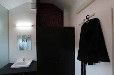 a bathroom with a black cabinet and a sink at MCC Hostel in Celje