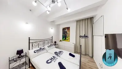 a bedroom with a bed with white sheets and blue pillows at Chaplin Apartment - Free Garage Parking in Ljubljana
