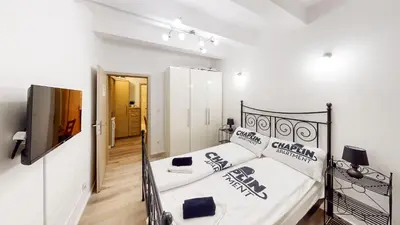 a bedroom with a bed and a television in it at Chaplin Apartment - Free Garage Parking in Ljubljana