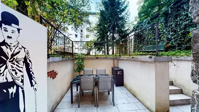 a balcony with two chairs and a painting on the wall at Chaplin Apartment - Free Garage Parking in Ljubljana