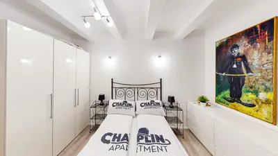 a bedroom with a bed and a painting on the wall at Chaplin Apartment - Free Garage Parking in Ljubljana