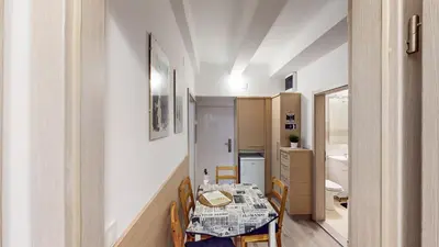 a small dining room with a table and a kitchen at Chaplin Apartment - Free Garage Parking in Ljubljana
