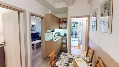 a kitchen with a table and a dining room at Chaplin Apartment - Free Garage Parking in Ljubljana