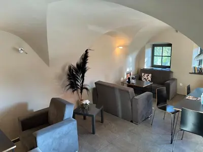 a waiting room with couches and tables in a building at Cukrarna Guest Accommodation in Kranj