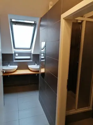 a bathroom with two sinks and a window at Cukrarna Guest Accommodation in Kranj