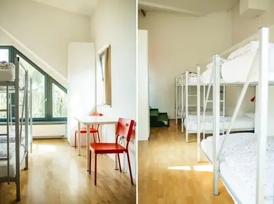 a room with two bunk beds and a table and chairs at Cukrarna Guest Accommodation in Kranj