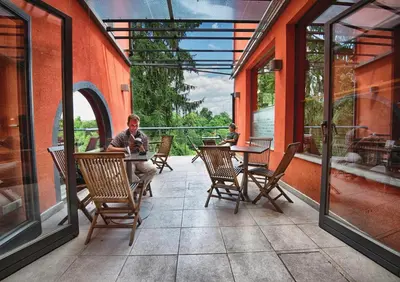 a man sitting at a table on a patio at Cukrarna Guest Accommodation in Kranj