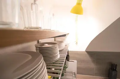 a stack of plates on a shelf in a kitchen at The Maze Apartment in Ljubljana