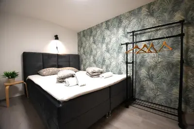 a bed in a room with a wall at The Maze Apartment in Ljubljana