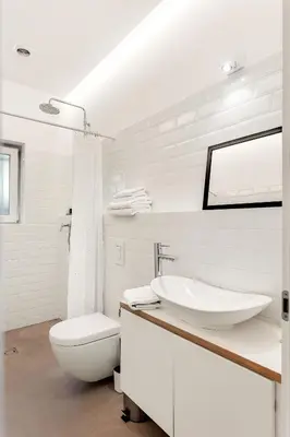 a white bathroom with a sink and a toilet at Pekarna apartments in Ljubljana