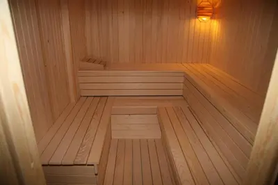 a wooden sauna with a bench in a wooden floor at House Berdnik in Stahovica