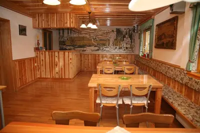a dining room with wooden tables and chairs at House Berdnik in Stahovica