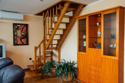a living room with a wooden spiral staircase at Apartment Bor in Bovec