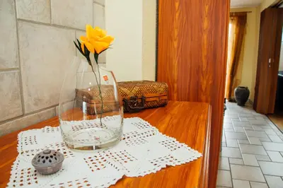 a vase with a yellow flower sitting on a table at Apartment Bor in Bovec