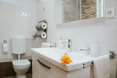 a white bathroom with a sink and a toilet at Apartment Bor in Bovec