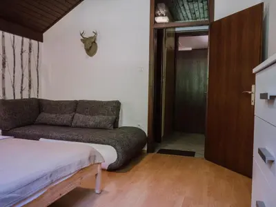 a small room with a couch and a door at TUBA Apartments in Bohinj