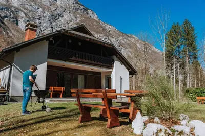 a woman standing in front of a house with a grill at TUBA Apartments in Bohinj