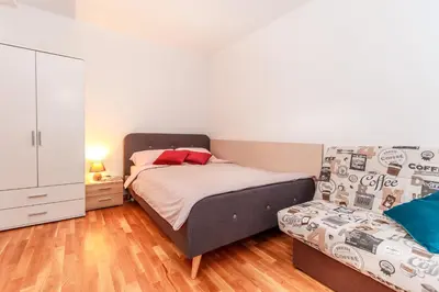 a bedroom with a bed and a dresser at Alp Apartma in Radovljica