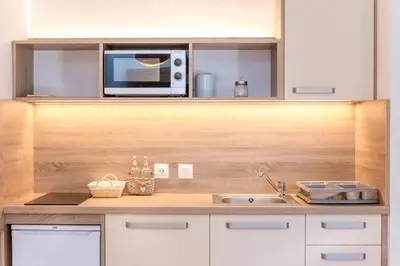 a kitchen counter with a microwave and a sink at Alp Apartma in Radovljica