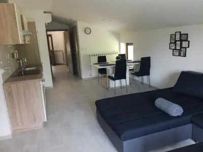 a living room with a blue couch and a table at Apartma Logar in Kobarid