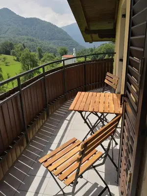 a balcony with two wooden chairs and a table at Apartma Logar in Kobarid