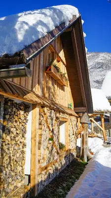 a log cabin with snow on top of it at Hike & Bike Chalet in Bohinj
