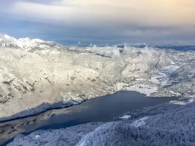 an aerial view of a snow covered mountain with a lake at Hike & Bike Chalet in Bohinj