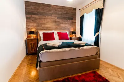 a bedroom with a large bed with red pillows at Apartments & Rooms Florjana in Bled