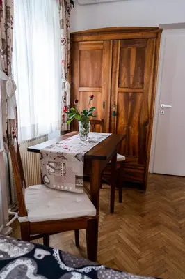 a dining room with a table with a vase on it at Apartments & Rooms Florjana in Bled