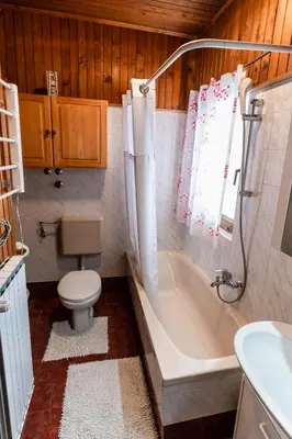 a bathroom with a toilet and a tub and a sink at Apartments & Rooms Florjana in Bled