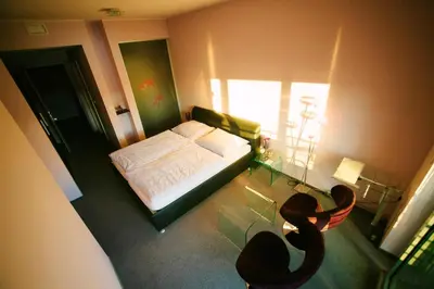 a small bedroom with a bed and a window at Šiker B&B Hotel in Pernica